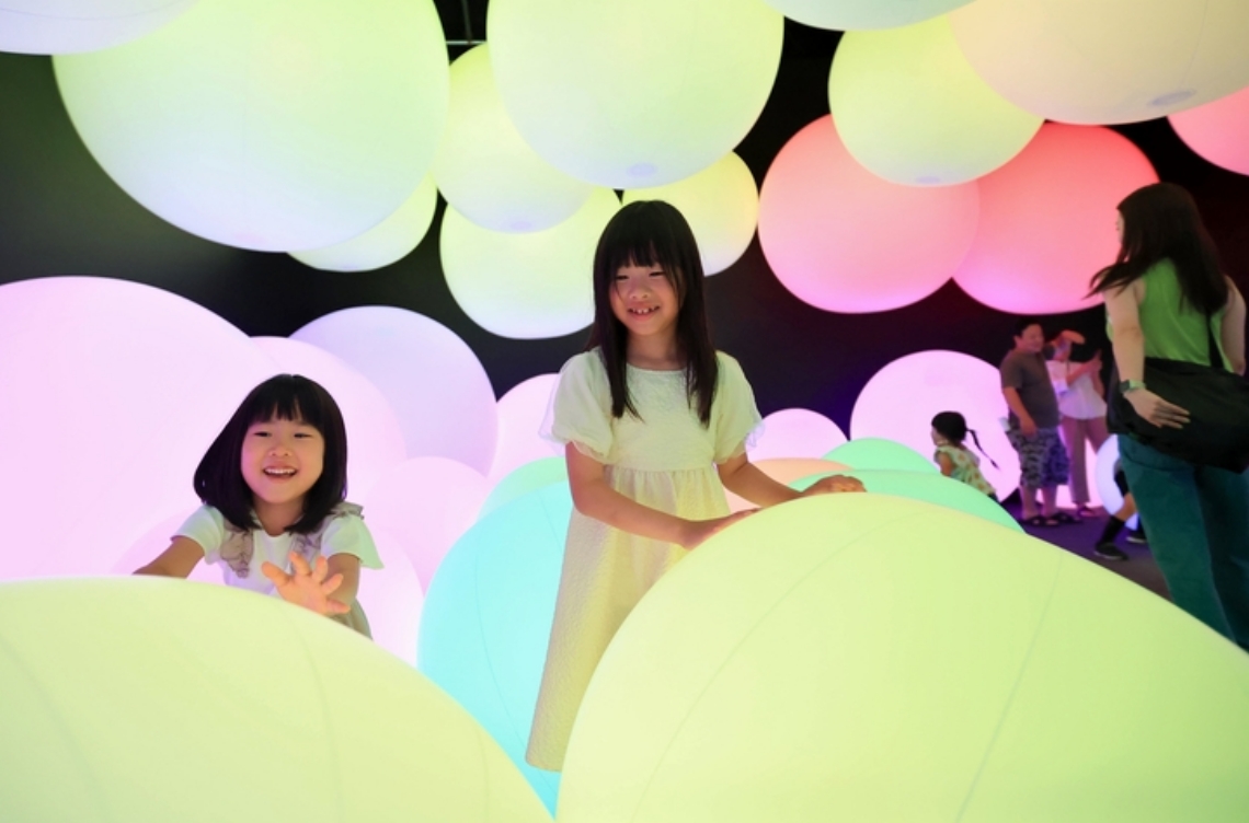 光るボールを転がして遊ぶ子どもたち