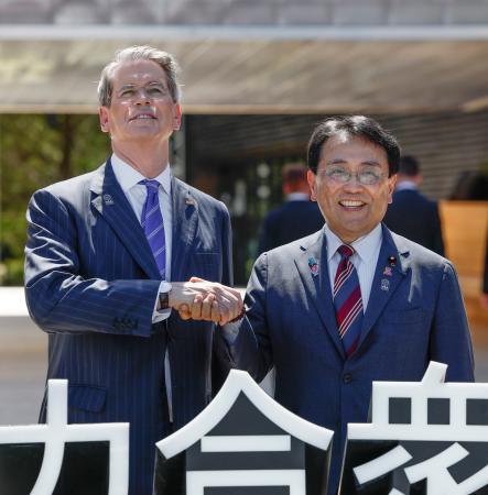 米国館の見学を前にベセント財務長官（左）と握手を交わす赤沢経済再生相＝１９日午後、大阪市此花区の夢洲
