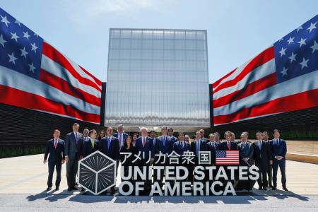 米国館の見学を前に、記念写真に納まる日米代表団ら＝１９日午後、大阪市此花区の夢洲