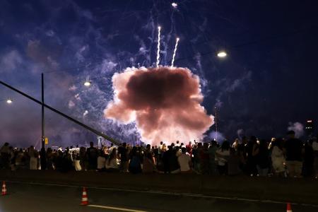 祭り会場の観衆の近くで爆発する花火＝１８日、デュッセルドルフ（ＤＰＡ提供・ＡＰ＝共同）