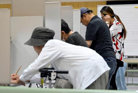 参院選で投票用紙に記入する有権者＝２０日午前、大阪市浪速区
