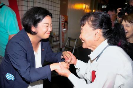 鹿児島選挙区で当選を決め、支持者と握手する尾辻朋実氏（左）＝２０日夜、鹿児島市