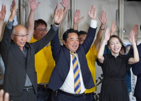 香川選挙区で当選を決め、支援者らと万歳する国民民主党の原田秀一氏（中央）＝２０日夜、高松市