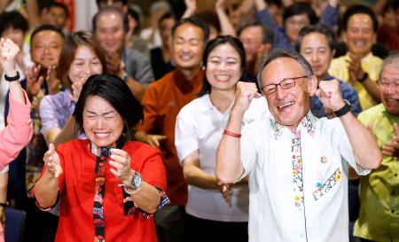沖縄選挙区で当選を決め、喜ぶ高良沙哉氏。右は沖縄県の玉城デニー知事＝２０日夜、那覇市