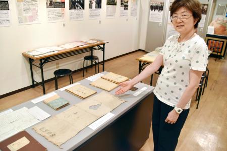 有罪判決を受けた人が獄中で使用したタオルを紹介する高麗博物館の円谷恵専務理事＝９日、東京都新宿区