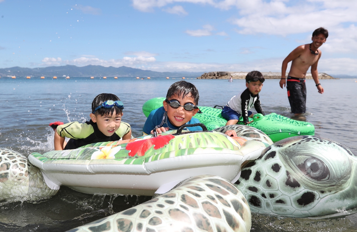 照りつける日差しの下、海水浴を楽しむ子どもたち