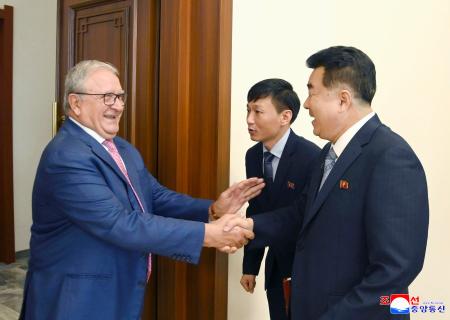 世界野球ソフトボール連盟のリカルド・フラッカリ会長（左）と握手する北朝鮮オリンピック委員会委員長の金日国体育相＝２２日、平壌（朝鮮中央通信＝共同）
