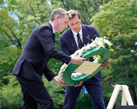 長崎市の爆心地公園で花輪を手向けるフリードネス氏（右）＝２３日午後