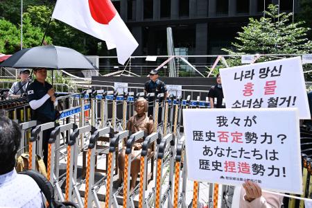 旧日本軍の従軍慰安婦問題を象徴する少女像（中央）の前で右派団体が開いた集会＝２３日、ソウル（共同）