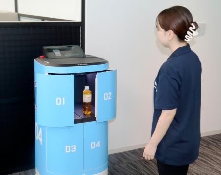 ＫＤＤＩの本社で、ロボットがローソンの商品を従業員に届ける実演＝２４日午後、東京都港区