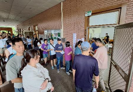 ２６日、台北市の投票所で列に並ぶ有権者ら（共同）