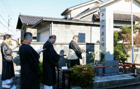 「模擬原爆」の犠牲者を追悼する式典で、慰霊碑の前で読経する僧侶＝２６日朝、富山市