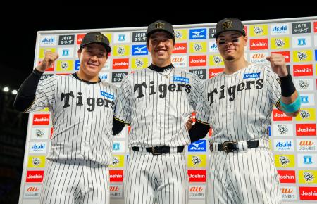 お立ち台でポーズをとる阪神の（左から）大山、才木、佐藤輝＝甲子園