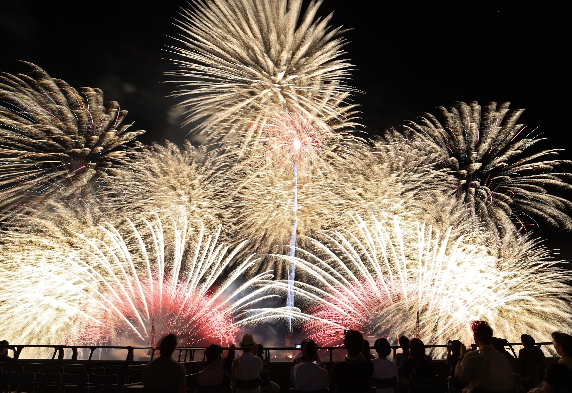 泉都の夜空に輝く８８８８発の花火（３枚の写真を比較明合成）＝２７日夜、別府市北浜緑地帯