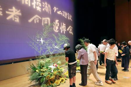 「相模湖・ダム建設殉職者合同追悼会」で献花する参列者＝２７日午後、相模原市緑区