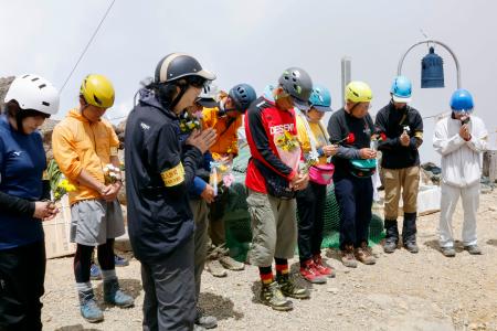 御嶽山山頂で黙とうする遺族ら＝２７日午前