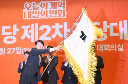 韓国の保守系少数野党「改革新党」の代表に選出され、党旗を振る李俊錫氏＝２７日、ソウル（共同）