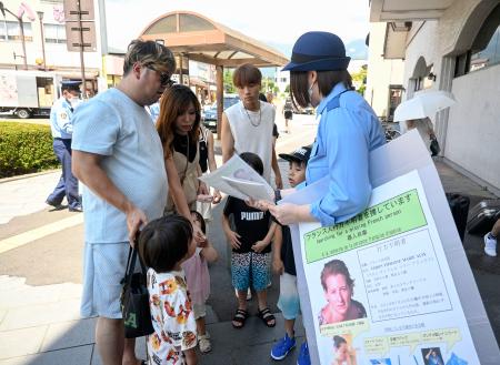 栃木県日光市で、ベロンさんの情報提供を求めチラシを配る日光署員＝２８日午前
