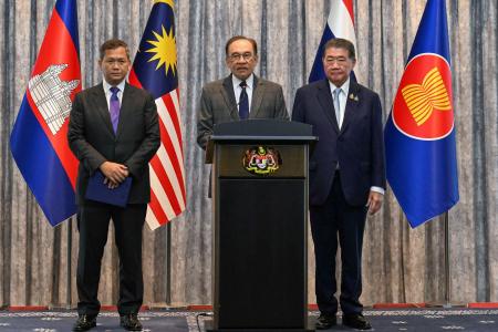 記者会見するマレーシアのアンワル首相（中央）。右はタイのプムタム首相代行、左はカンボジアのフン・マネット首相＝２８日、クアラルンプール近郊（ロイター＝共同）