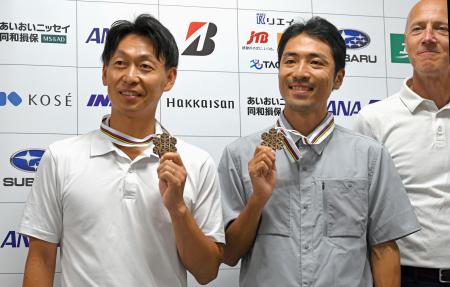 ２０１９年のノルディックスキー世界選手権複合団体の銅メダルを授与され、ポーズをとる（左から）永井秀昭さんと渡部善斗＝２９日、東京都新宿区