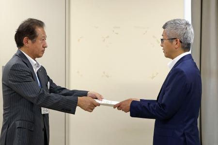 東北電力女川原発敷地内に「乾式貯蔵施設」を設置する計画について、宮城県庁で担当者（左）から回答書を受け取る東北電原子力本部の阿部正信原子力部長＝２９日午後