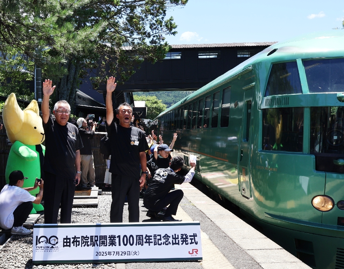 出発の号令を掛ける石橋隆一駅長（前列右）と相馬尊重市長＝由布市湯布院町川北