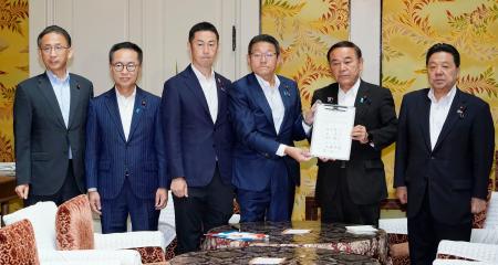 ガソリン税の暫定税率廃止法案の提出に向け、署名した合意文書を手に写真に納まる自民党の坂本国対委員長（右から２人目）、立憲民主党の笠国対委員長（同３人目）ら＝３０日午前、国会