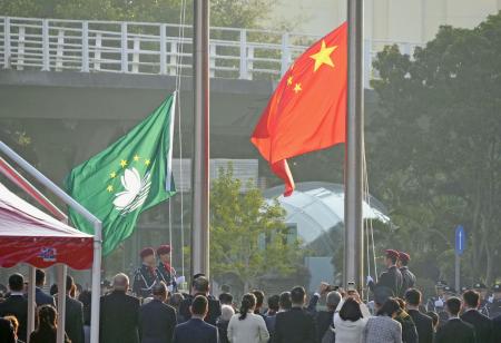 掲揚される中国国旗（右）とマカオの旗＝２０２４年１２月、マカオ（共同）