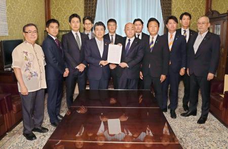 衆院事務総長（中央右）にガソリン税の暫定税率廃止法案を共同提出する野党議員＝１日午前、国会