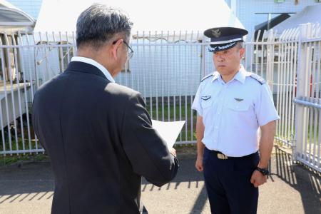 航空自衛隊新田原基地の担当者に申し入れをする宮崎県の岩切達哉県議（手前）＝１日午後、新富町