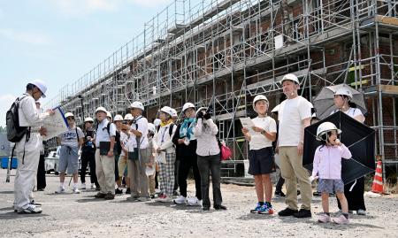 「旧広島陸軍被服支廠」の安全対策工事の現場見学会で、説明を受ける小学４年久保結正さん（右から４人目）ら参加者＝３日午前、広島市南区