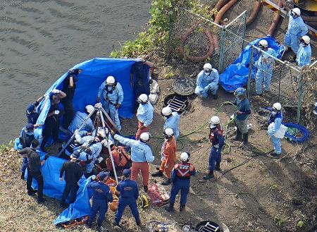 ２日、作業員４人がマンホールの中に転落した現場で救助活動に当たる消防隊員ら＝埼玉県行田市（共同通信社ヘリから）