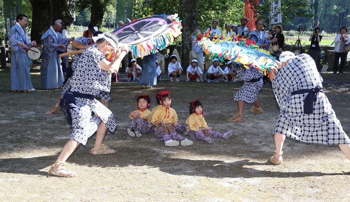 かっぱ役の幼児を唐うちわであおぐ男衆＝中津市耶馬渓町宮園の雲八幡宮