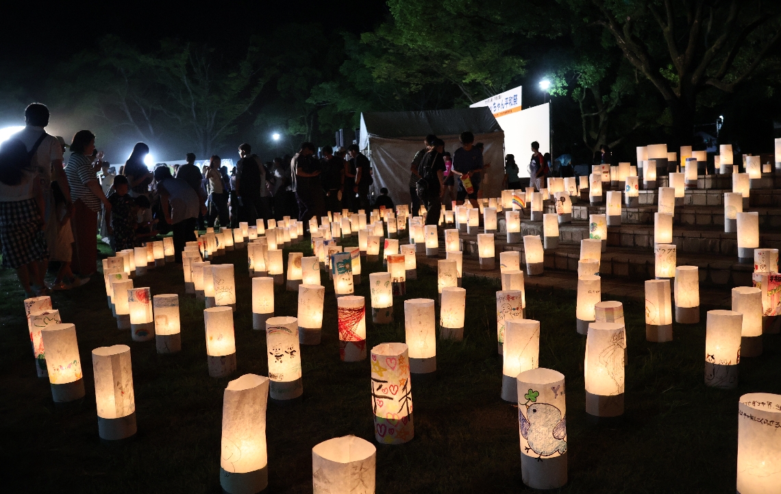 ハトのイラストや「平和」の文字が描かれた紙灯籠＝大分市牧の平和市民公園