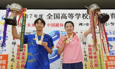 表彰式を終え、笑顔でトロフィーを掲げる男子シングルス優勝の星槎国際横浜・川上（左）と女子シングルス優勝の山陽学園・面手＝ＪＣＯＭアリーナ下関