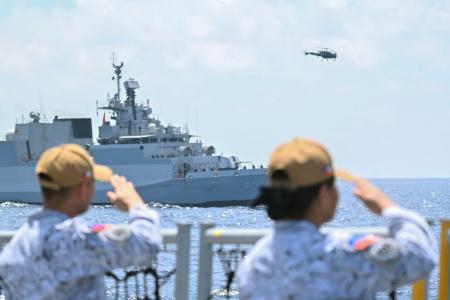 ４日、フィリピン西方沖の南シナ海で、インド軍艦に敬礼するフィリピン軍兵士ら（共同）