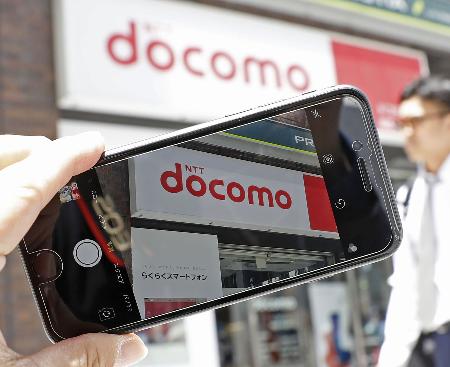 スマホに映るＮＴＴドコモの看板＝東京・銀座