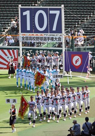 第１０７回全国高校野球選手権大会の開会式で、入場行進する横浜（手前）の選手ら。厳しい暑さへの対策として初めて夕方から実施された＝５日、甲子園球場