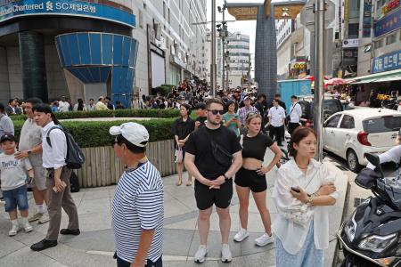 ５日、韓国・ソウルの明洞にある新世界百貨店に爆発物を仕掛けたとの投稿があり、避難した人たち（聯合＝共同）