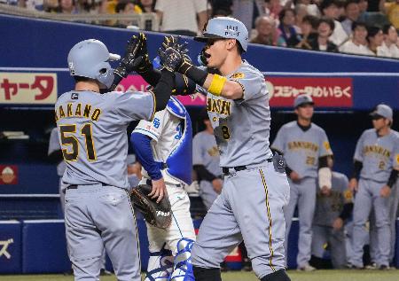 ８回、３ランを放ち中野（左）とタッチを交わす阪神・佐藤輝＝バンテリンドーム