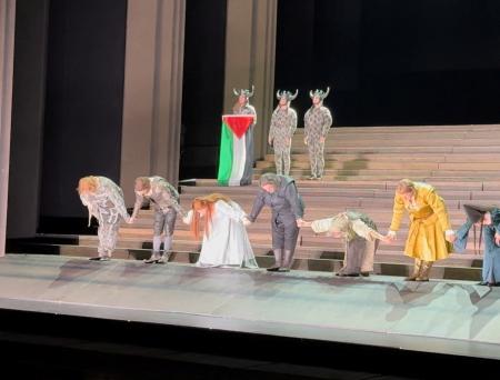 ロンドンのロイヤル・オペラ・ハウスで、カーテンコール中にパレスチナ旗を掲げる出演者＝７月１９日（＠ｓｙｄｃａｓ提供、ロイター＝共同）