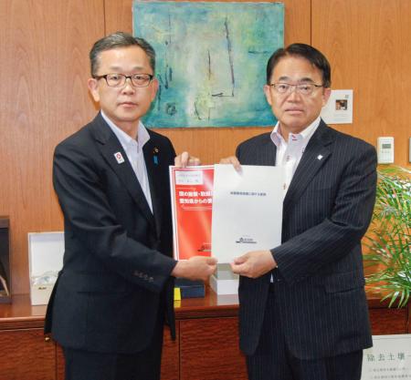 要請書を手に写真撮影に応じる愛知県の大村秀章知事（右）と経産省の竹内真二政務官＝６日、経産省
