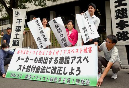 建設現場のアスベストを巡る訴訟で和解が成立し、横断幕を掲げる原告と弁護団＝７日午後、東京・霞が関
