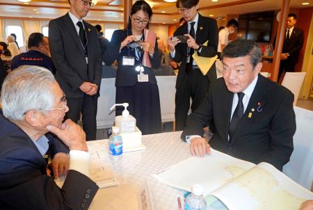 「洋上慰霊」の船内で、北方領土の元島民と交流する伊東沖縄北方相（右）＝７日午前、北海道根室市の根室港沖