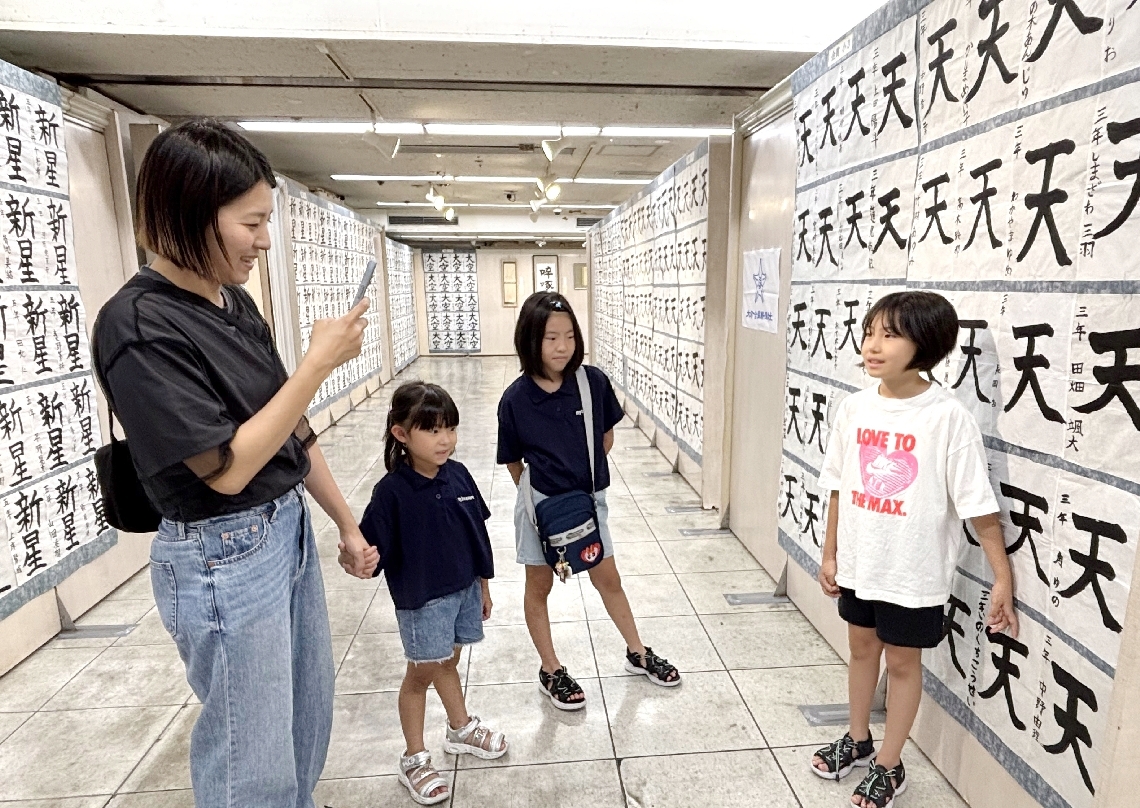 受賞した作品の前で記念撮影をする来場者＝８日、大分市のトキハ本店