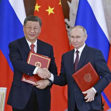 共同声明に署名し握手する中国の習近平国家主席（左）とロシアのプーチン大統領＝５月、モスクワ（新華社＝共同）