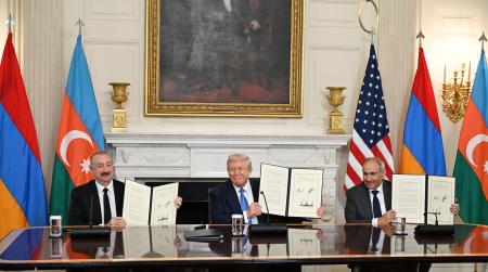 ８日、米ホワイトハウスで共同宣言に署名したアゼルバイジャンのアリエフ大統領（左）とアルメニアのパシニャン首相（右）、中央は仲介したトランプ米大統領（アゼルバイジャン大統領府提供、ゲッティ＝共同）