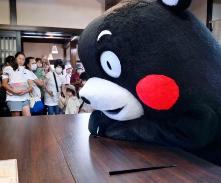 輪島塗の体験施設で箸を制作する「くまモン」＝９日午前、石川県輪島市