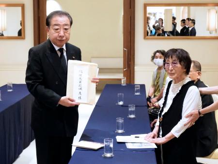 被爆体験者の岩永千代子さん（右）から石破首相宛ての要望書を預かった立憲民主党の野田代表＝９日午前、長崎市