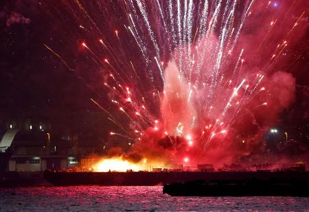 横浜市で開かれていた花火大会で、炎上する海上の台船から打ち上がる花火＝４日